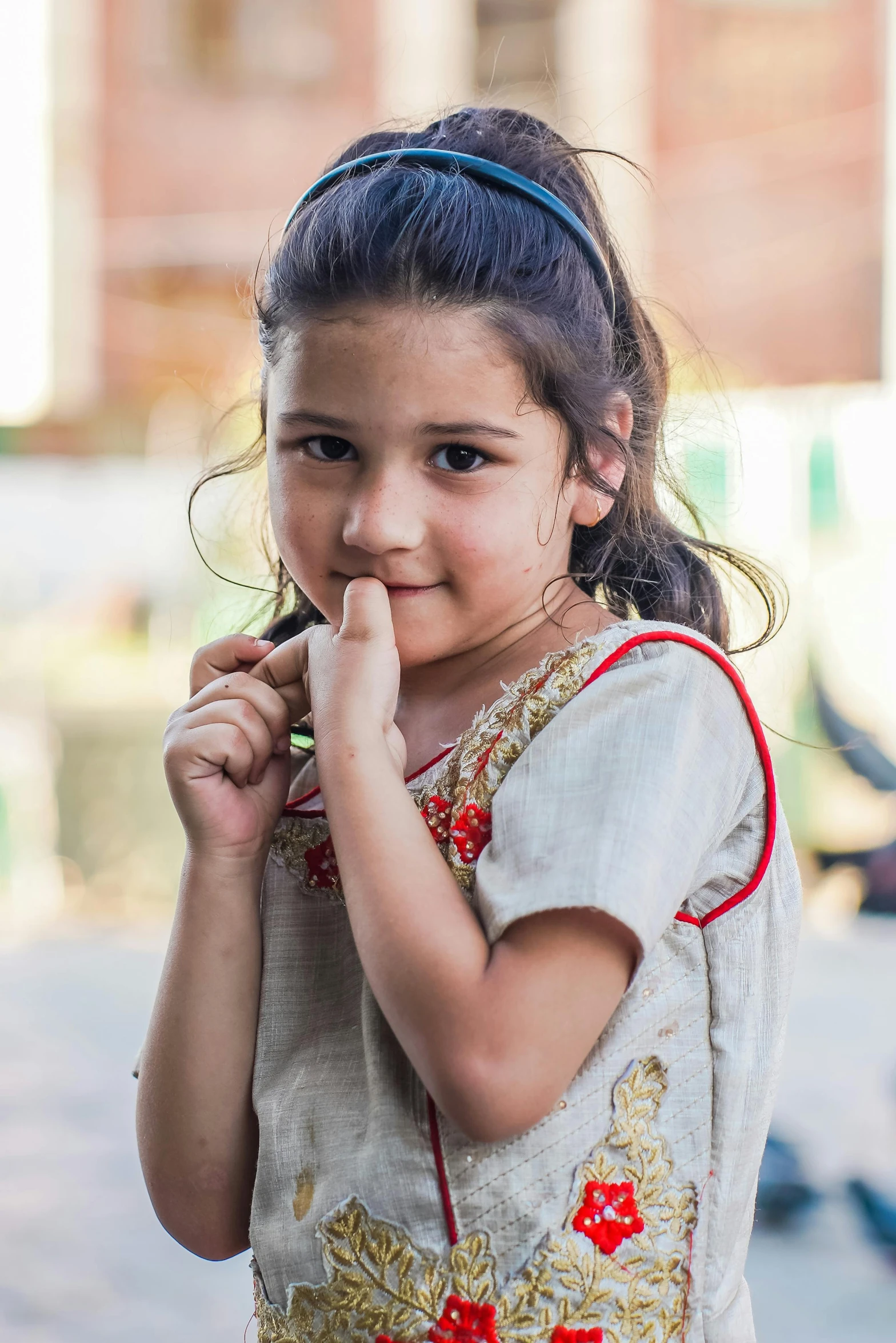  in traditional dress and earrings smiles