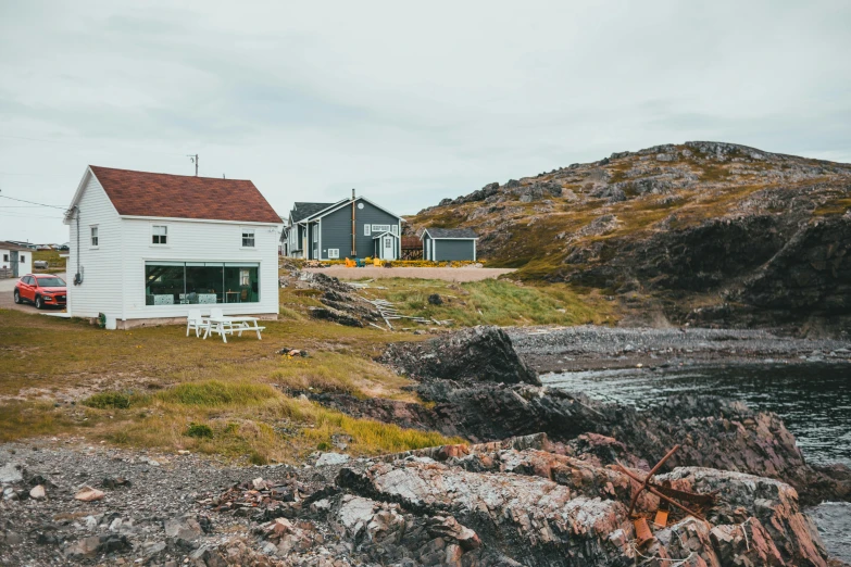 a small white house sitting next to some water