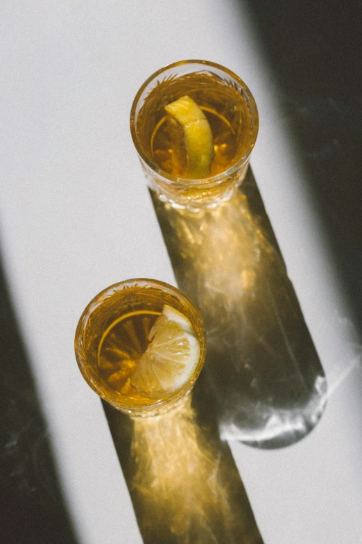 two glasses filled with drinks sitting next to each other