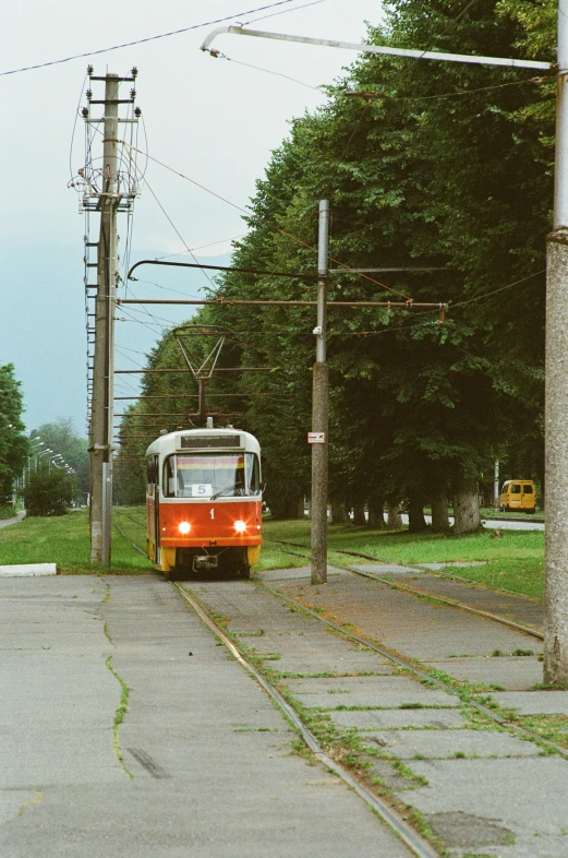 a train is traveling past a street and telephone poles