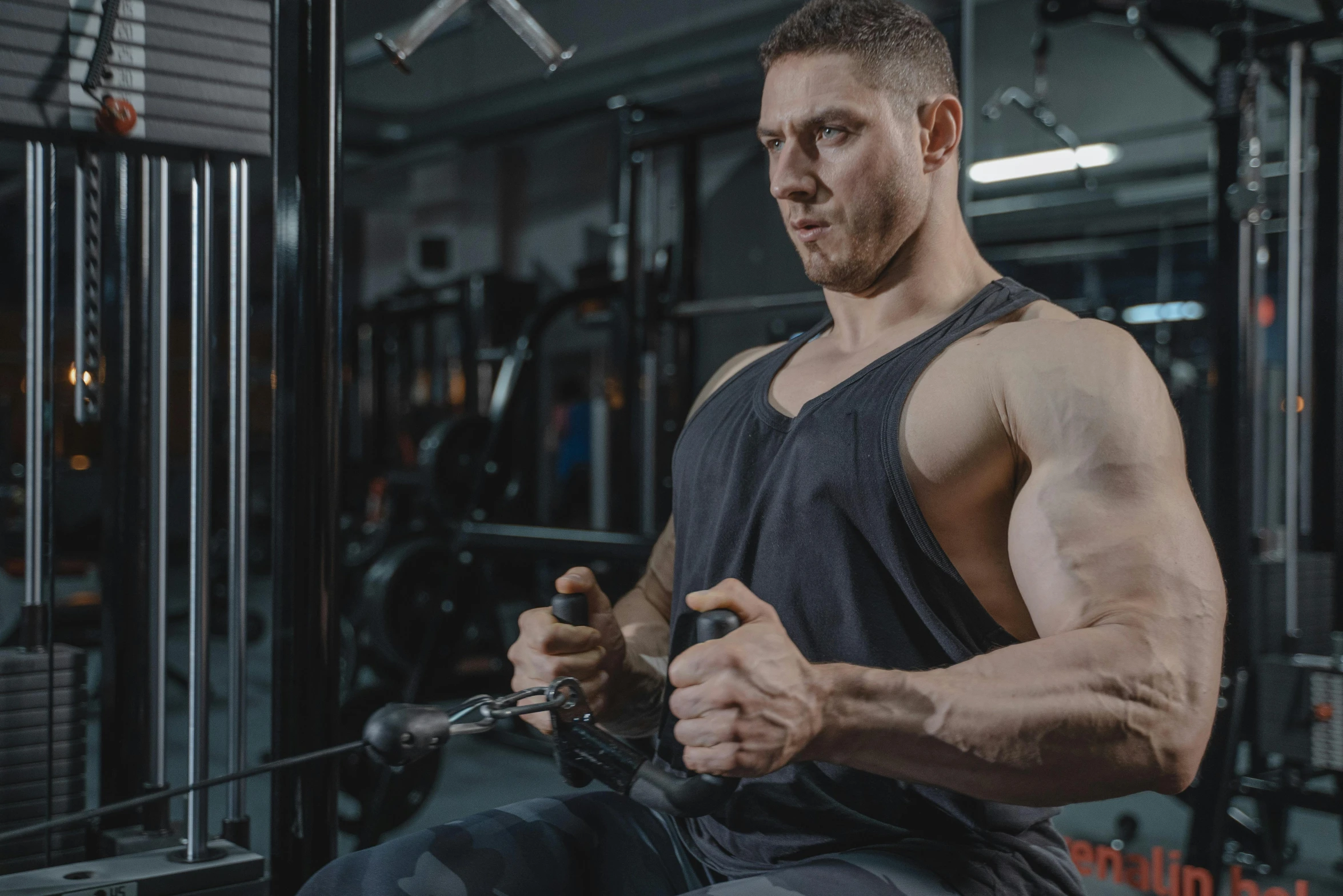 man squatting on a rope in gym