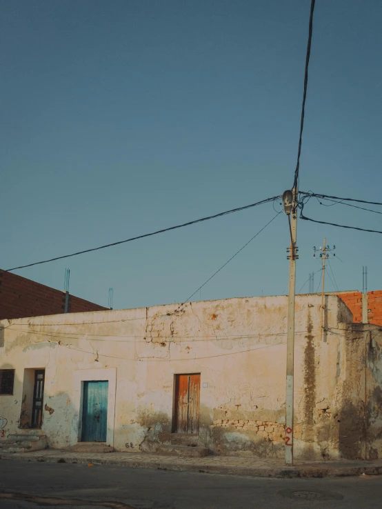 a very old building with a fence and wires hanging over the building