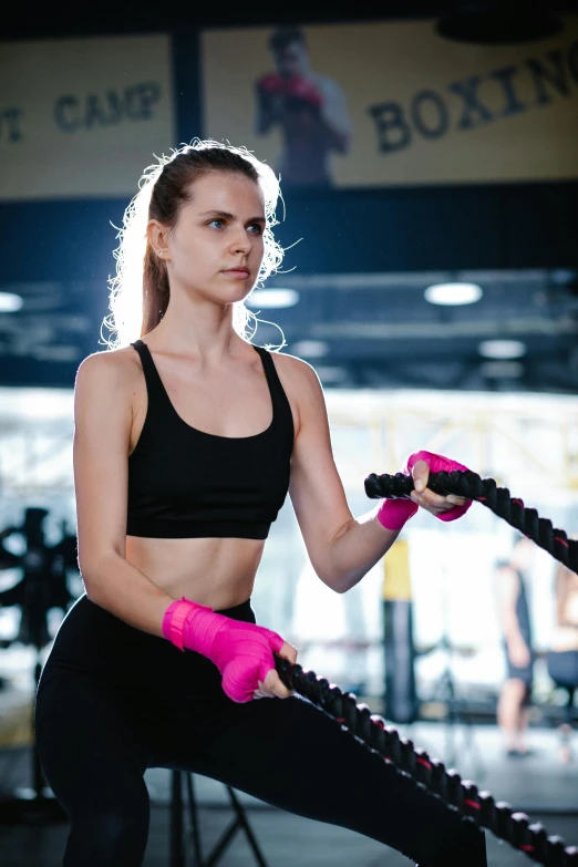 a woman holding two pink gloves while posing for a po