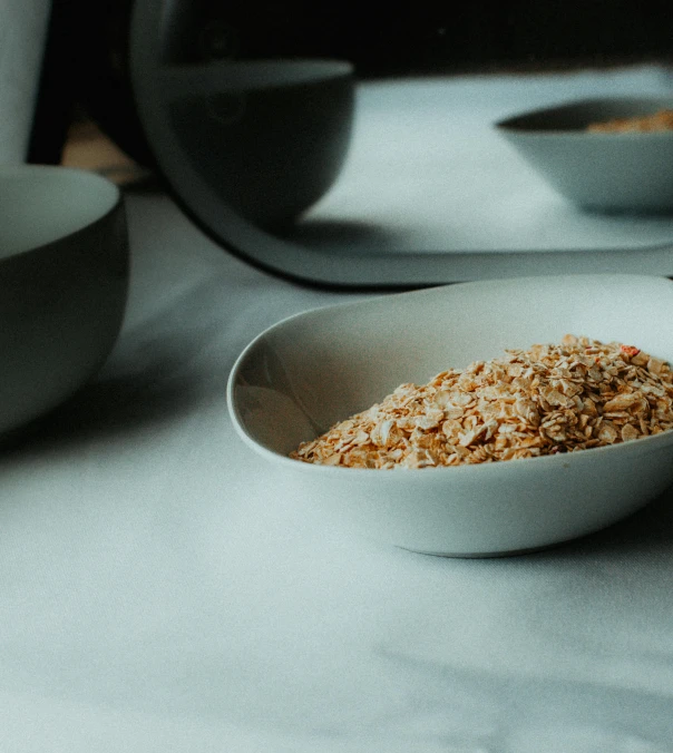 the white bowl is filled with cereal and ready to be eaten