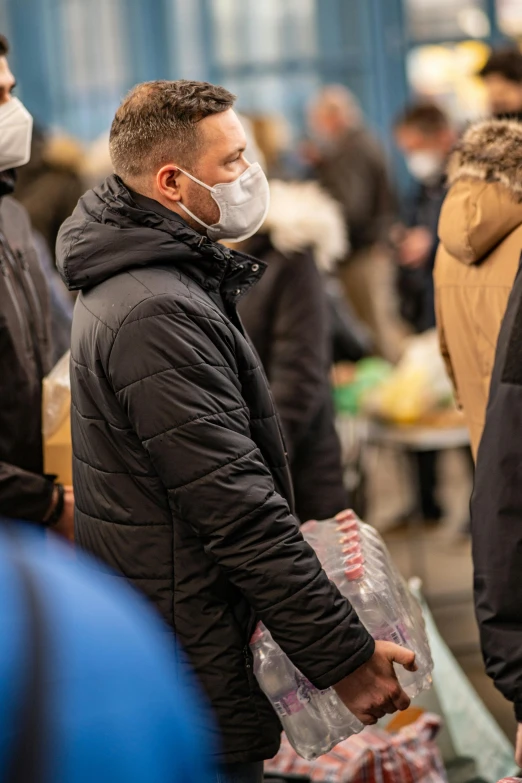 man in a mask with face covering looking at items