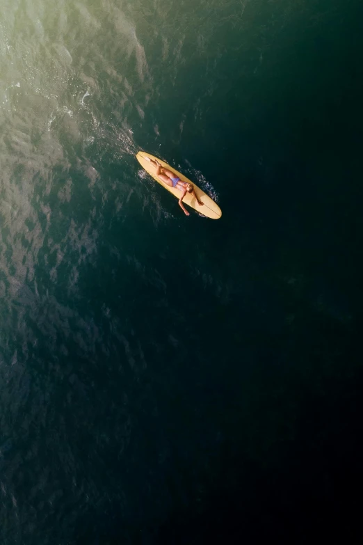 aerial view of a man laying on a surfboard