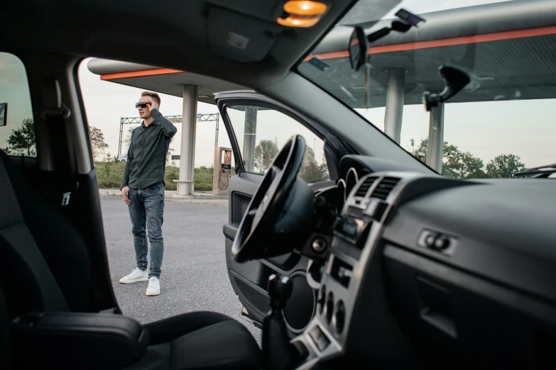 a man in a vehicle, standing near the driver's dashboard