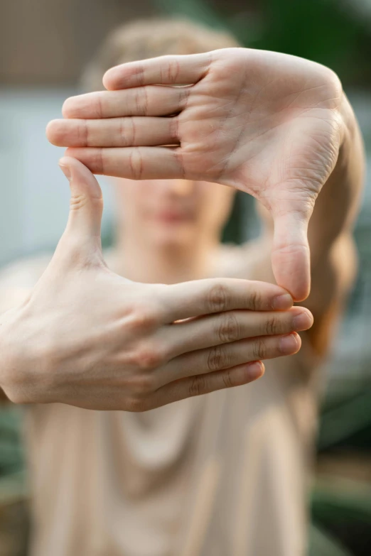 the person holding their hands up to show that they have two hands