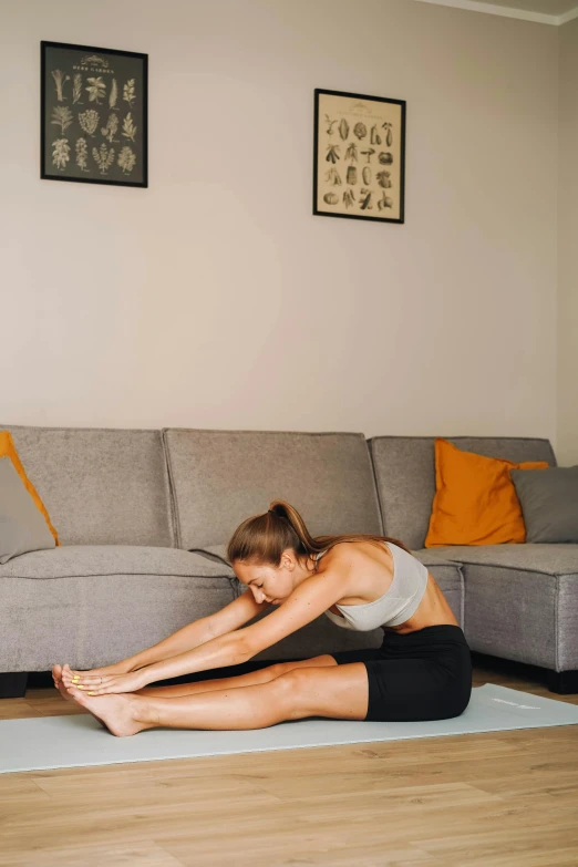 a young woman is practicing a yoga pose on the floor