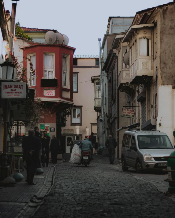 a small city street with several people walking in front of some shops