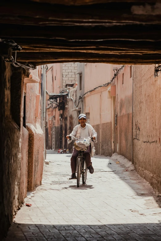 man on a bike riding through an alley way
