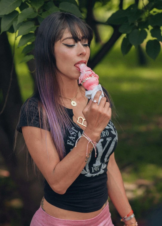 a woman with pink hair eats an object