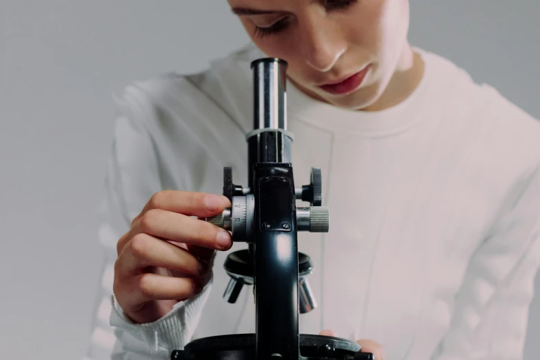 a girl looks at a telescope with her hands