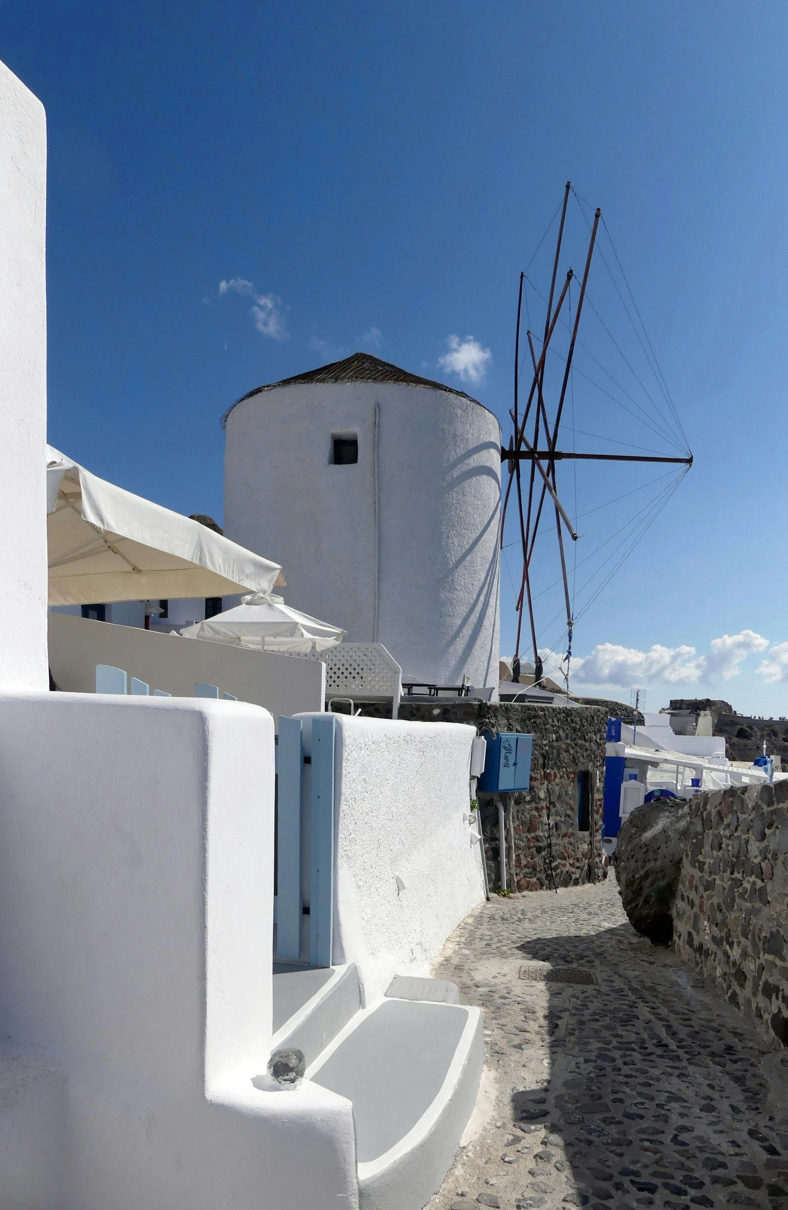 a windmill next to the whitewashed walls of a building