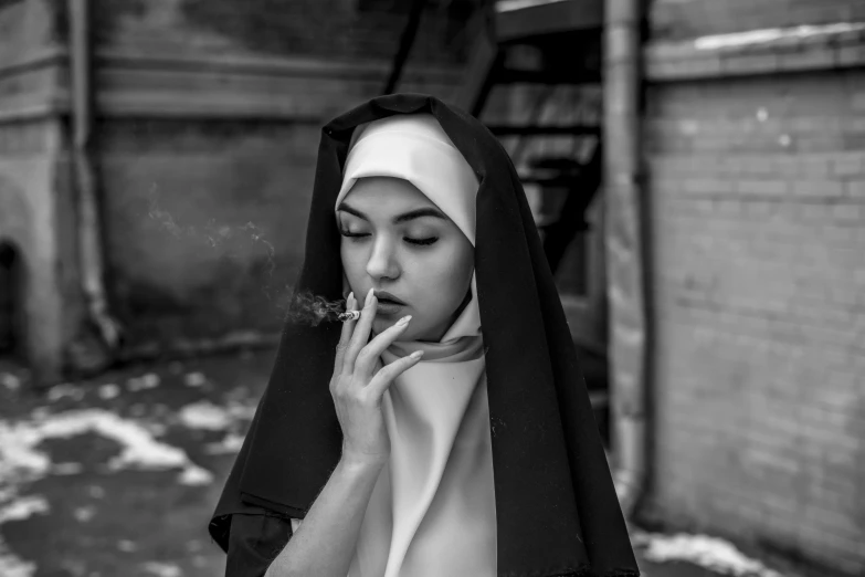 a nun smoking a cigarette while standing outside in front of a building