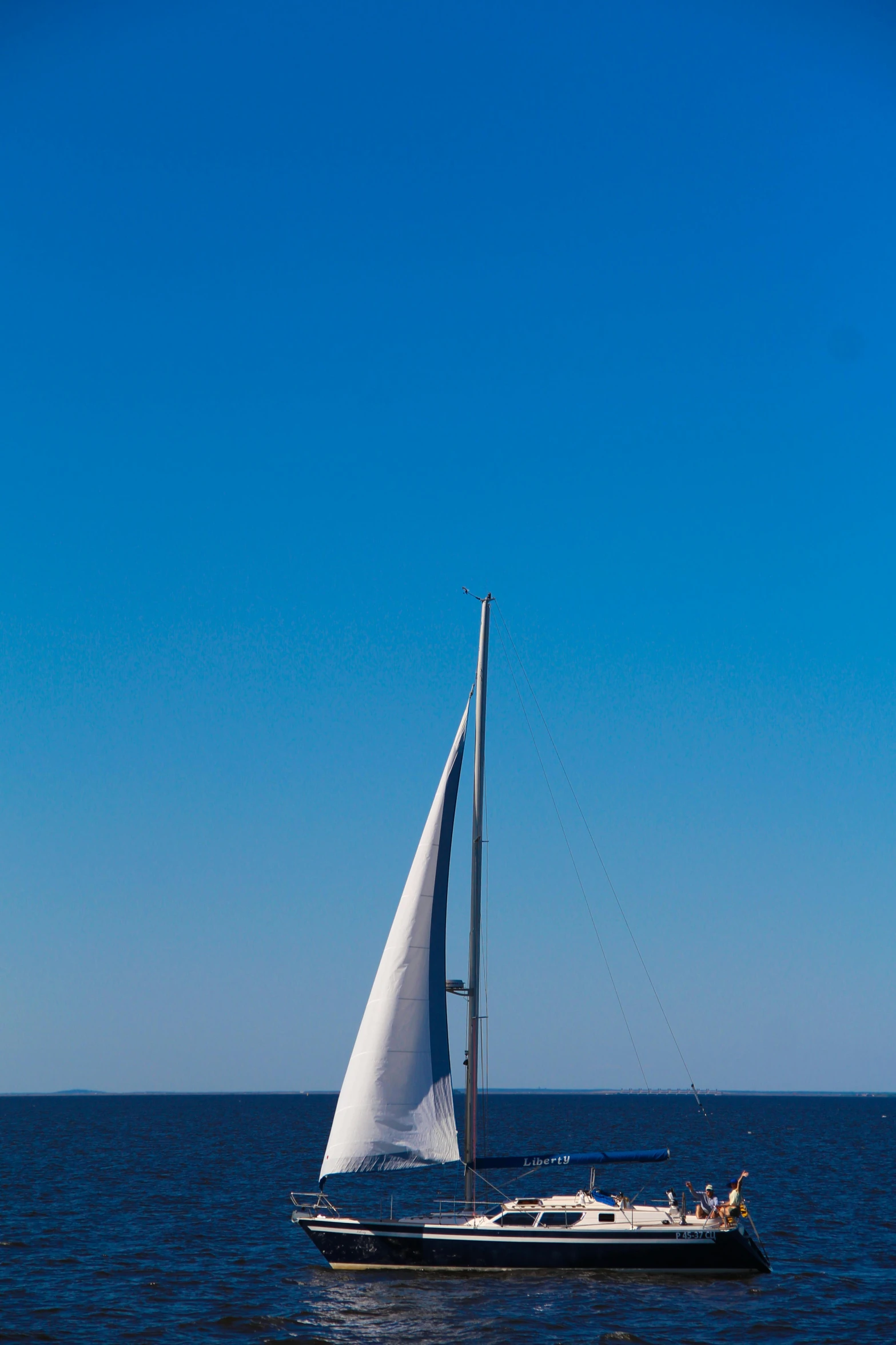 a small sail boat floating in the middle of the ocean