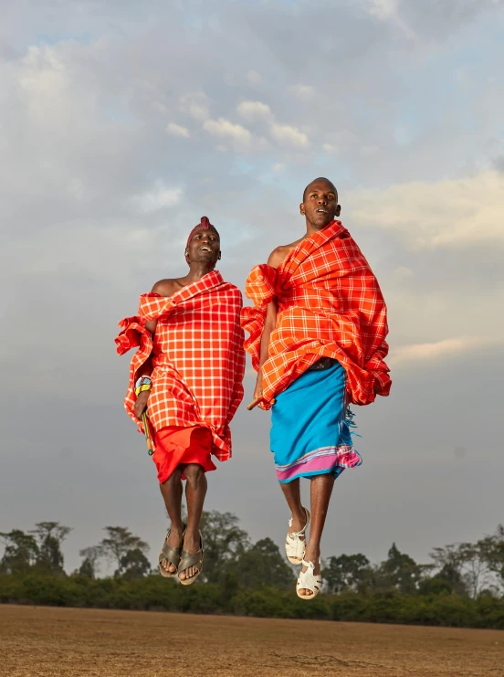 two men who are in the air above grass