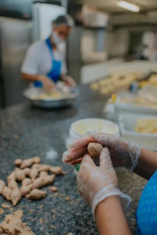 a woman with gloves and apron is putting food on the counter