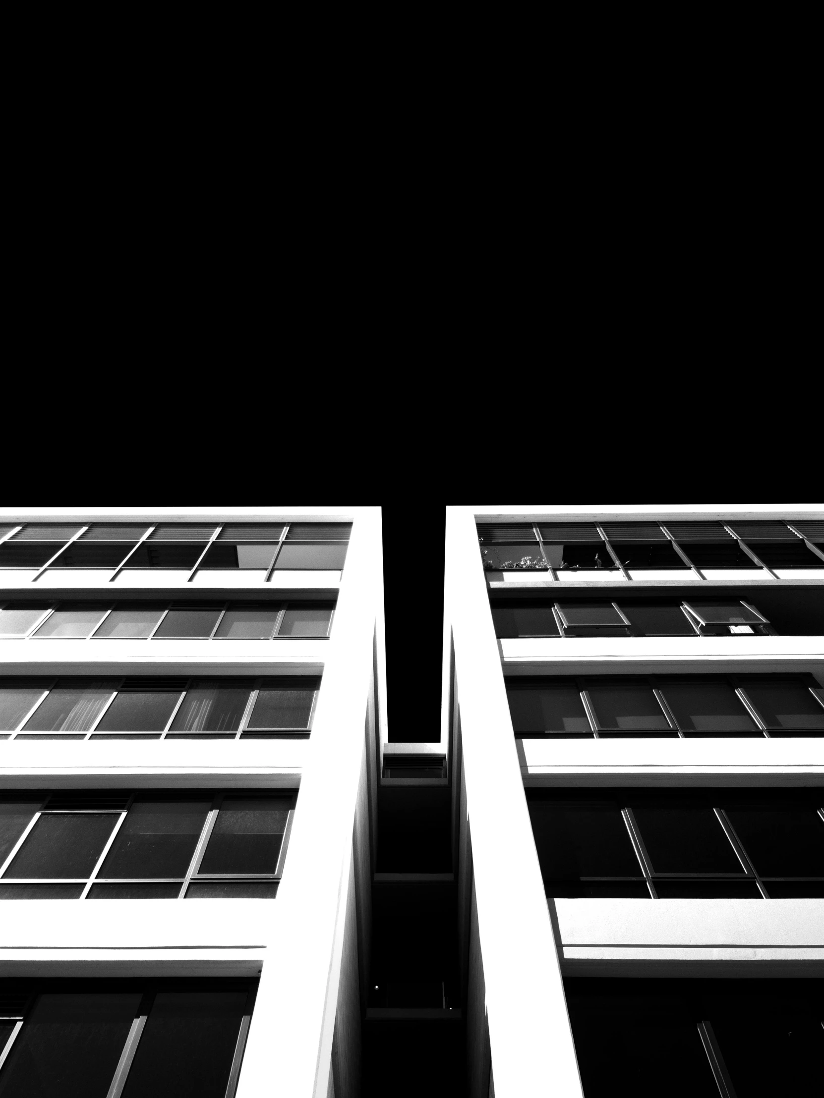 two very tall buildings next to each other in front of a black sky