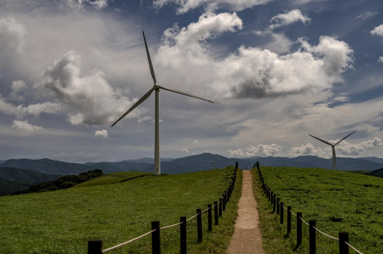 three wind turbines on top of a hill