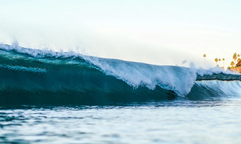 a surfer on a large wave coming up from the beach