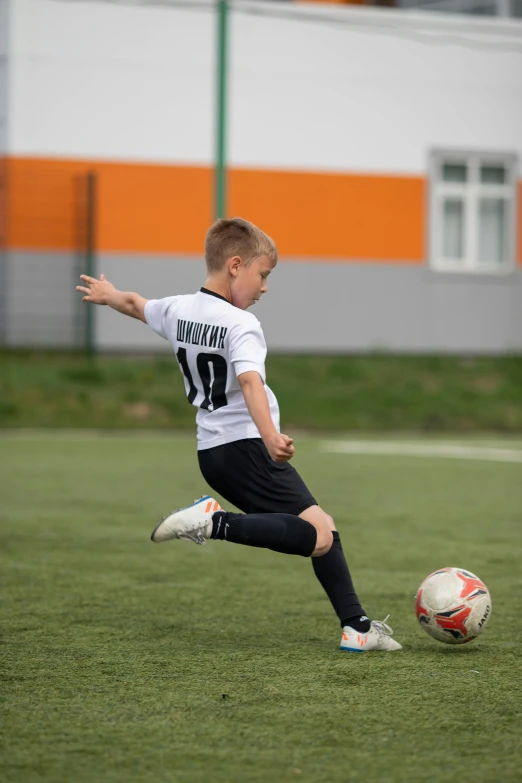 a  kicking a soccer ball on top of a field