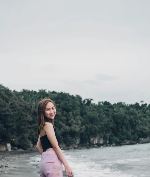 young woman with pink dress and blue boots looking at camera