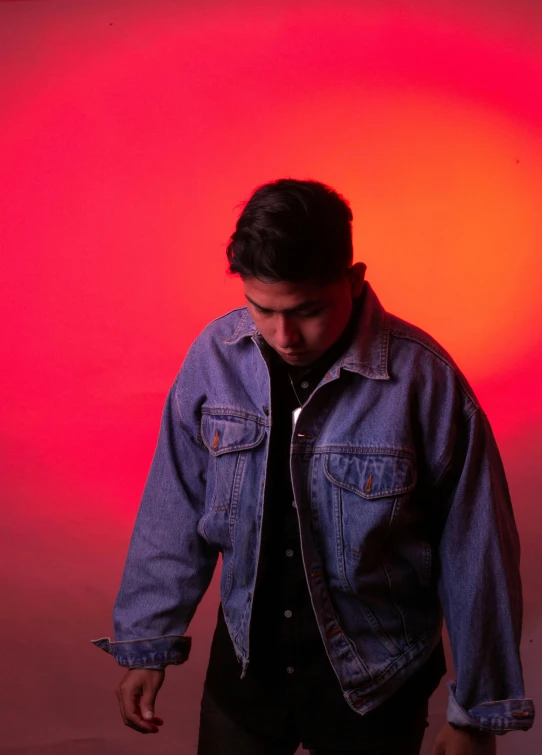 a man standing up against a pink background