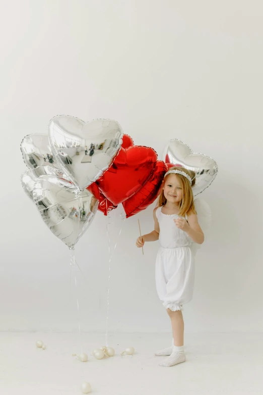 a  holds two large heart balloons