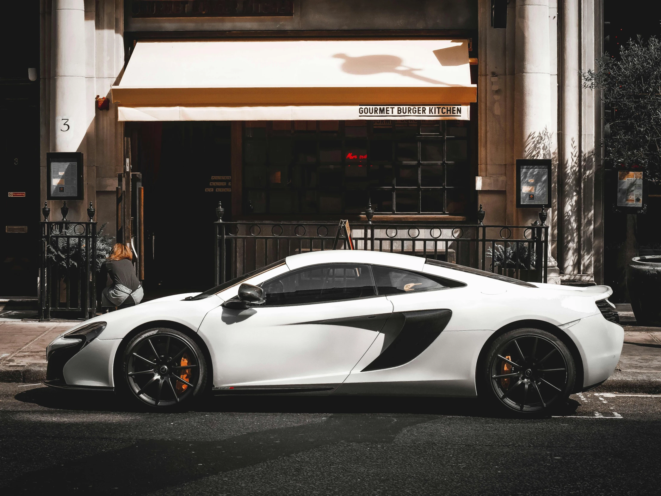 a white sports car sits on a city street