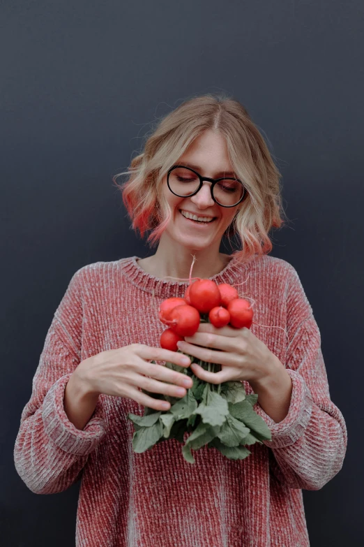 woman smiling with tomatoes in front of her