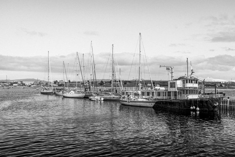 boats in a harbor with the sea and buildings in the background