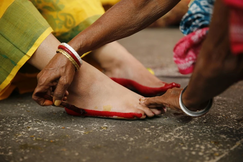 a person bending down with their feet covered in red paint