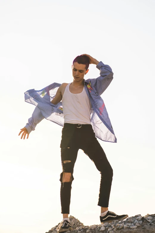 a man standing on a rock while wearing a blue and white scarf