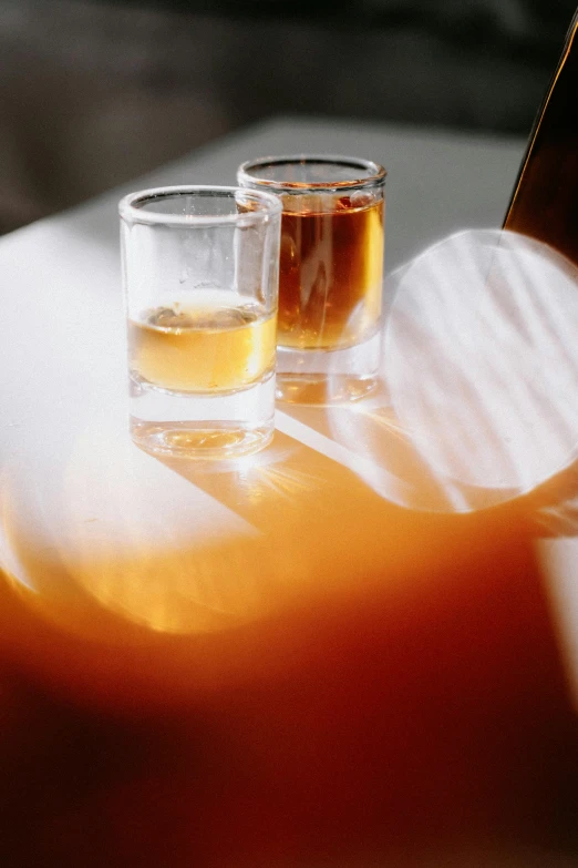 two glasses filled with liquid sitting on a table