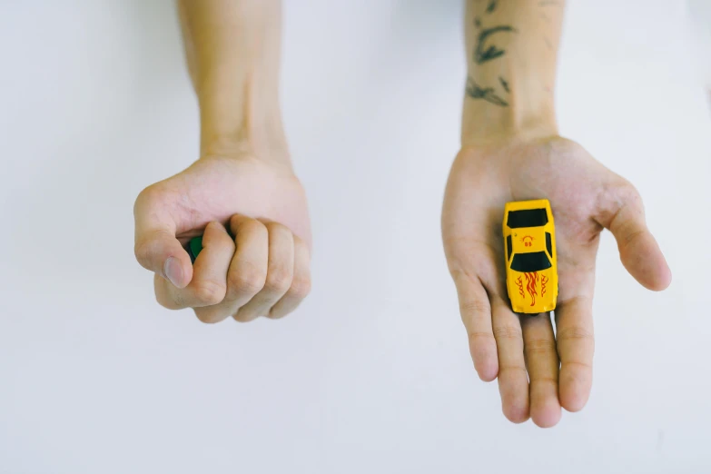 someone holding onto their hand a small yellow phone