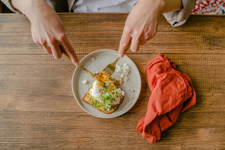 a woman sitting at a table eating from a plate