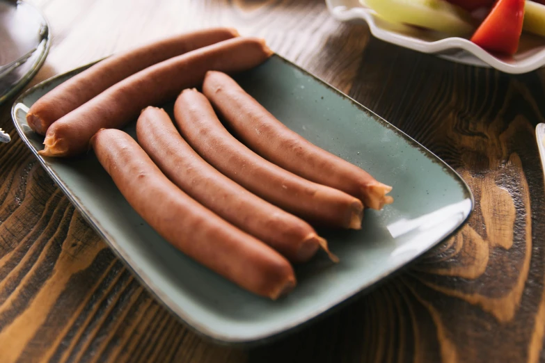 a plate with four  dogs and some apple slices