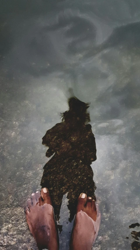 a woman is seen from the bottom view of a body of water