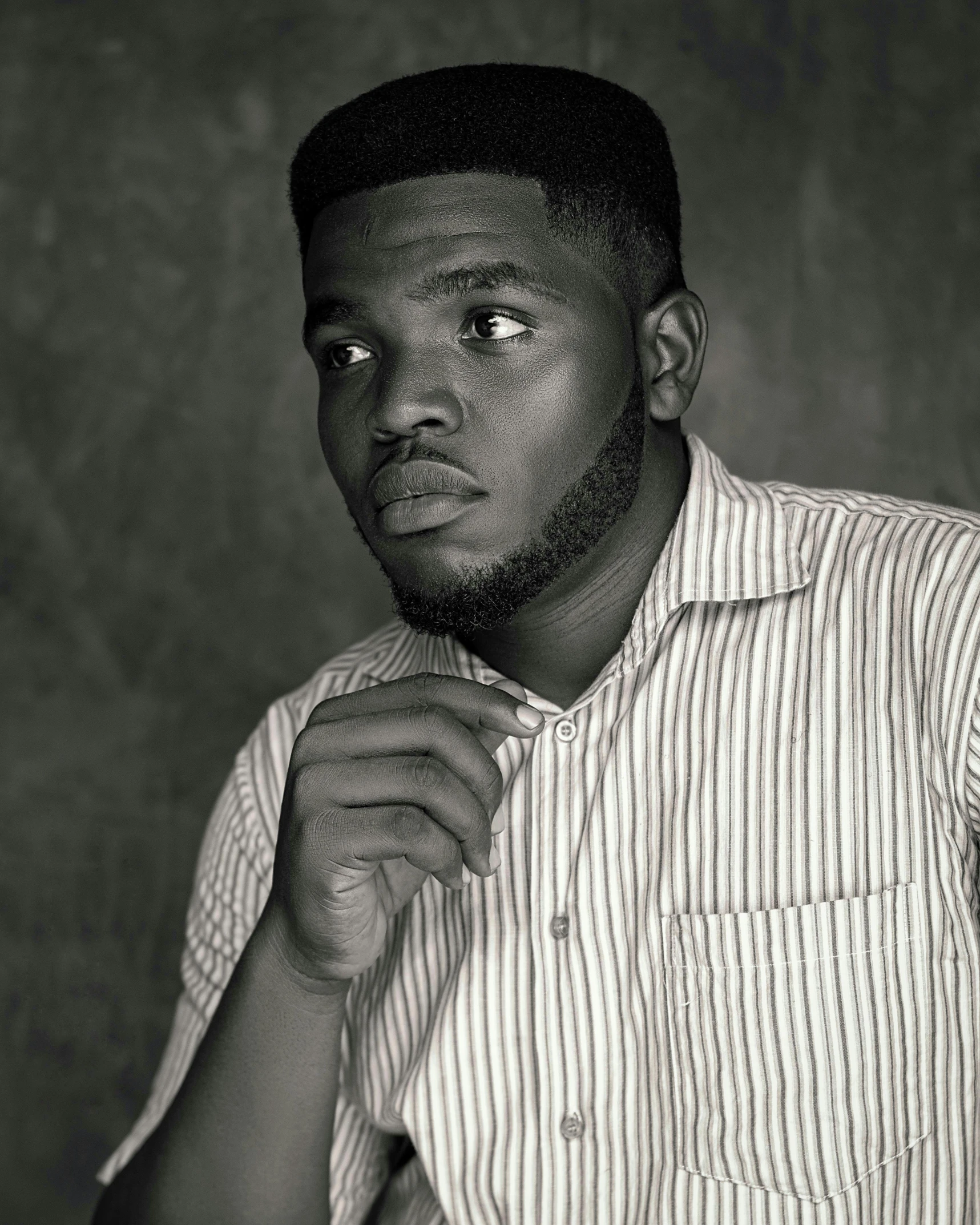 a man in striped shirt adjusting his tie