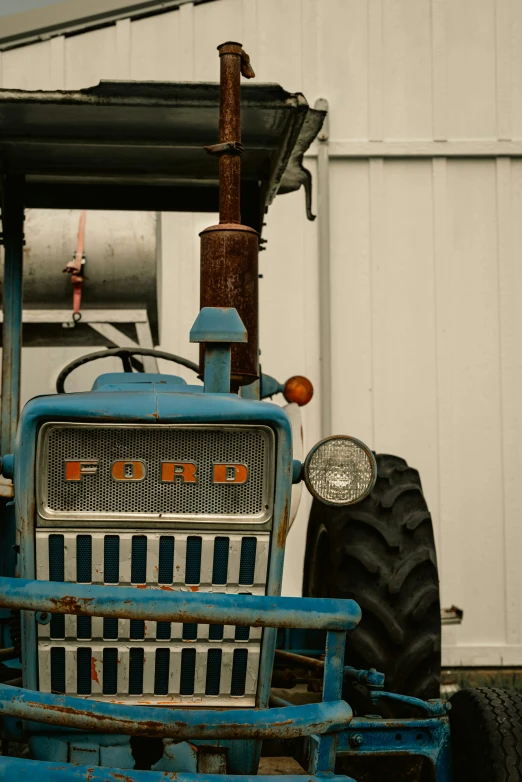 an old tractor that is parked in the yard