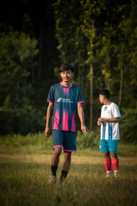 a boy and girl in an open field next to trees