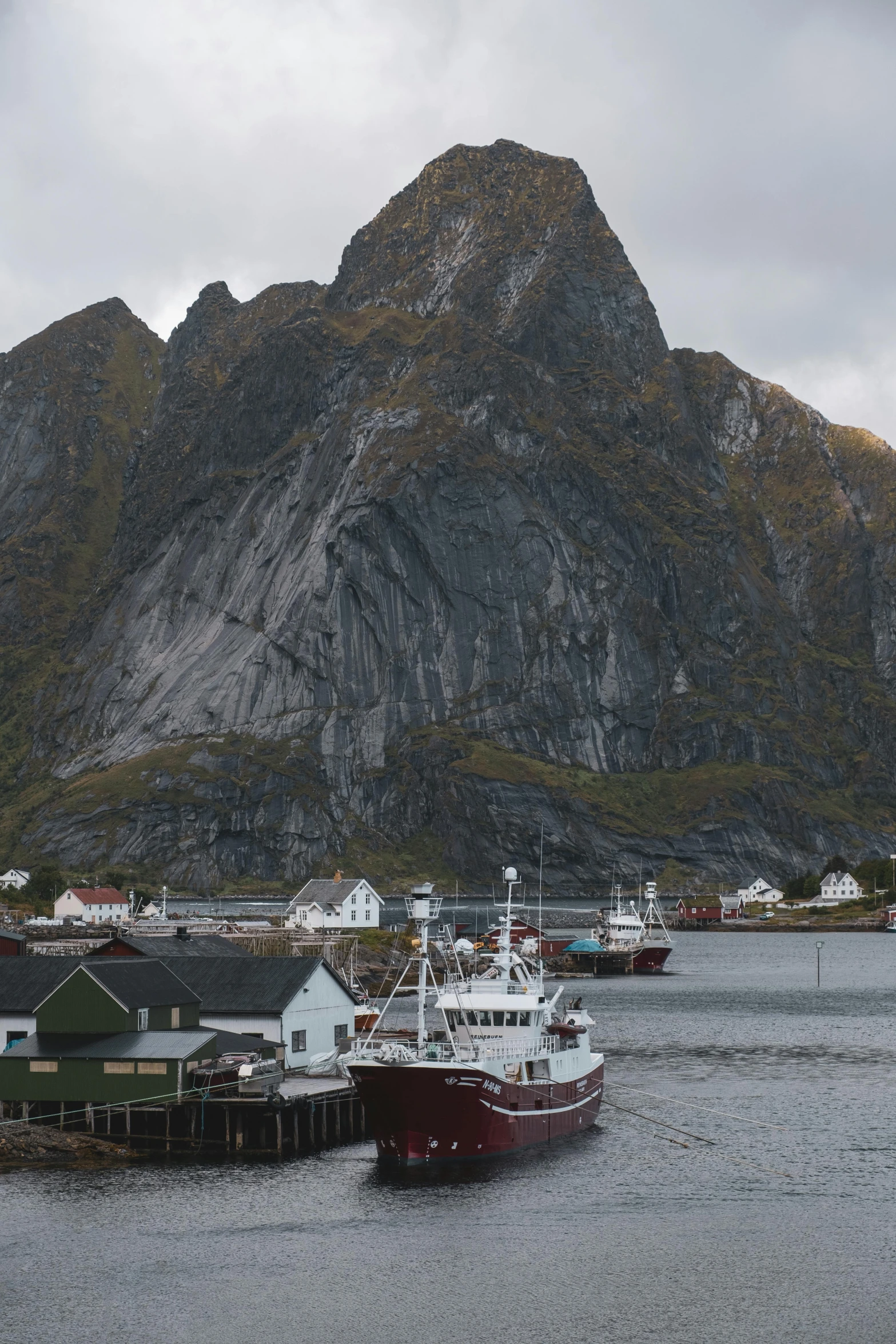 two boats in a body of water near a large mountain