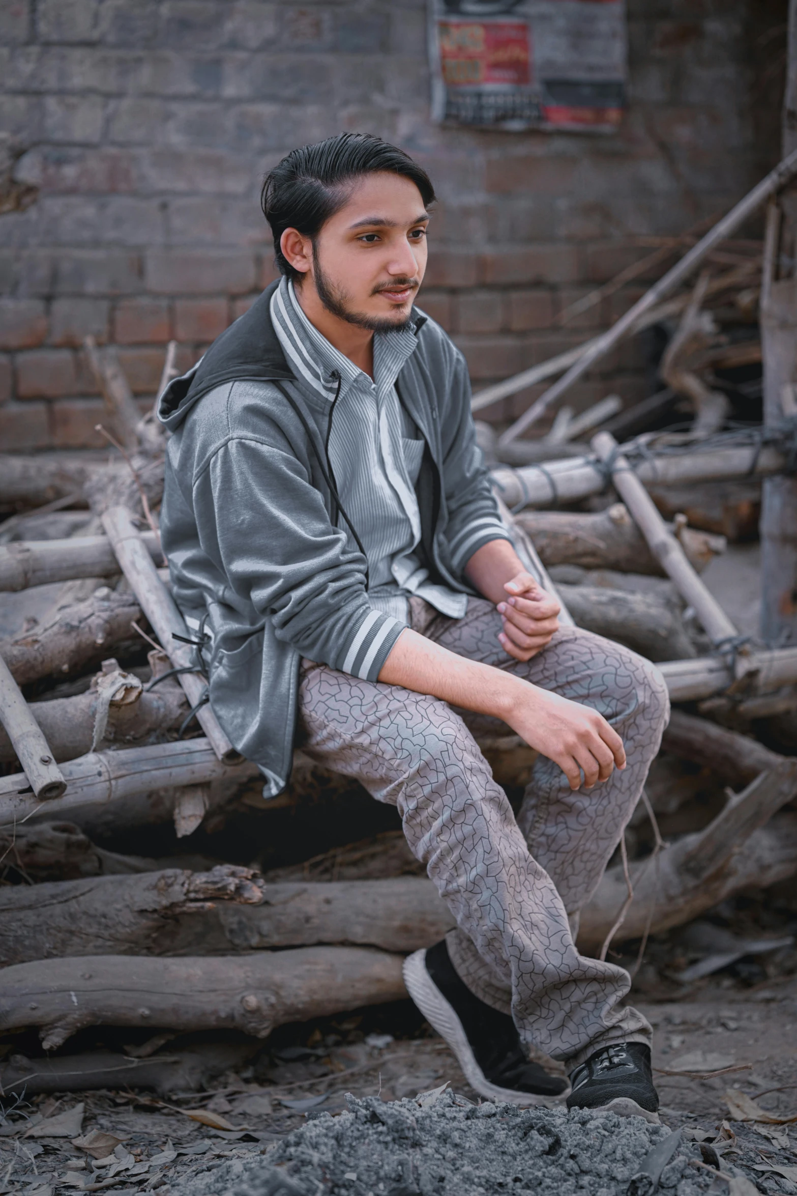 a man in gray jacket sitting on a log