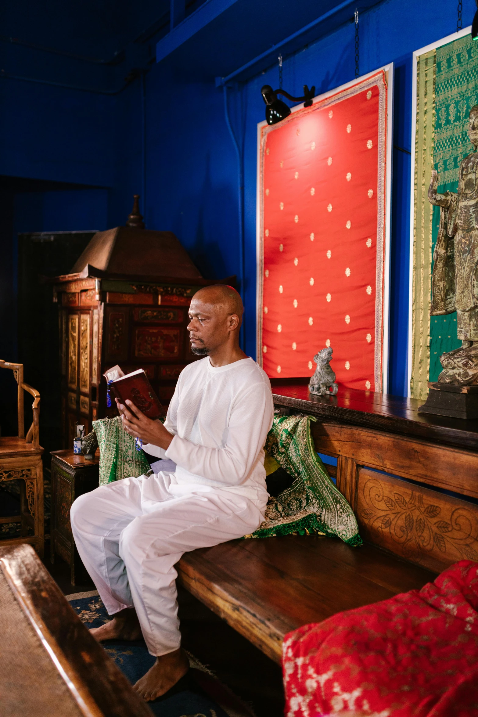 a man sitting on top of a bench next to a book