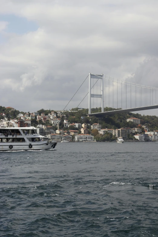 two boats in a body of water near a bridge