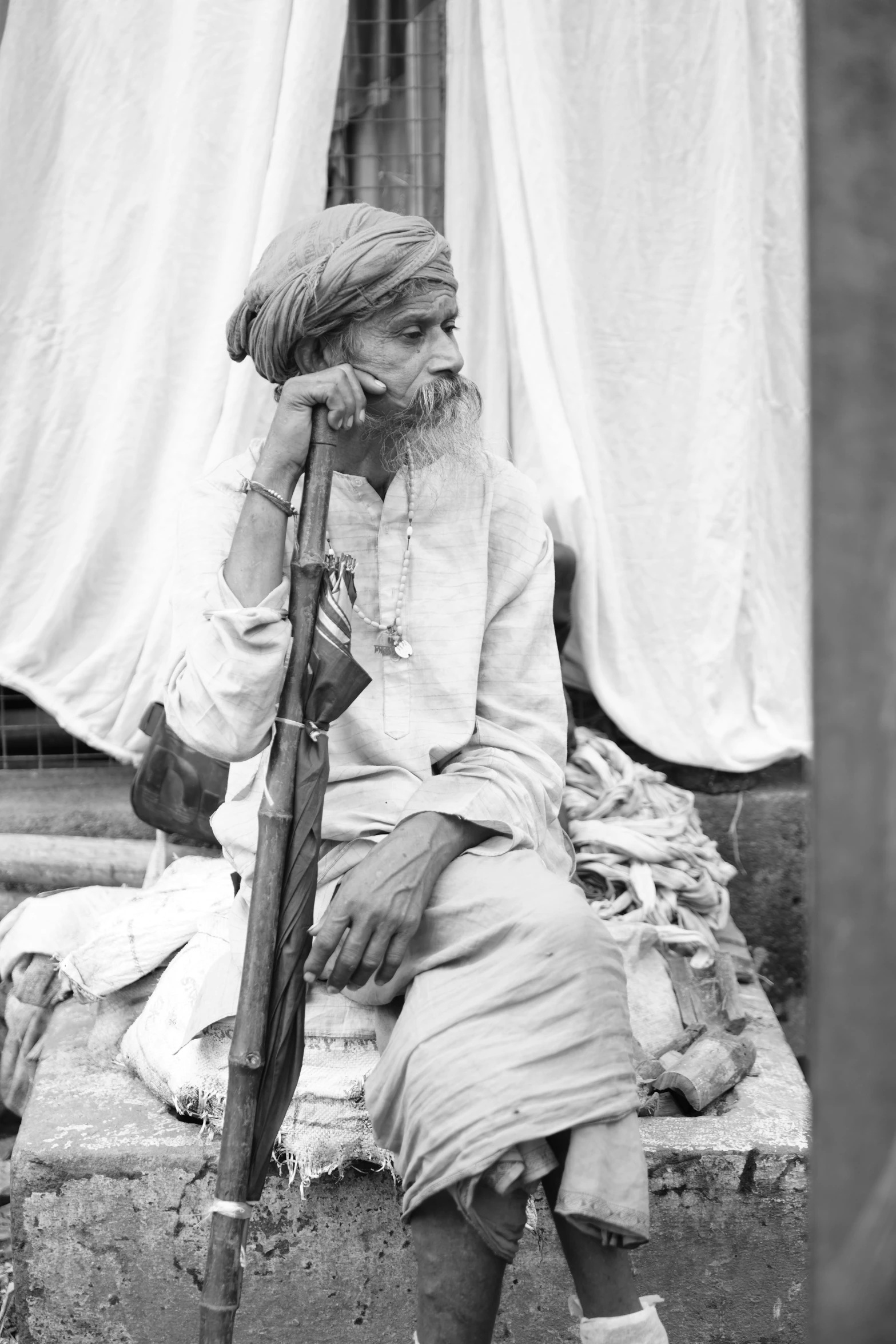 the old man sits on steps with his cane