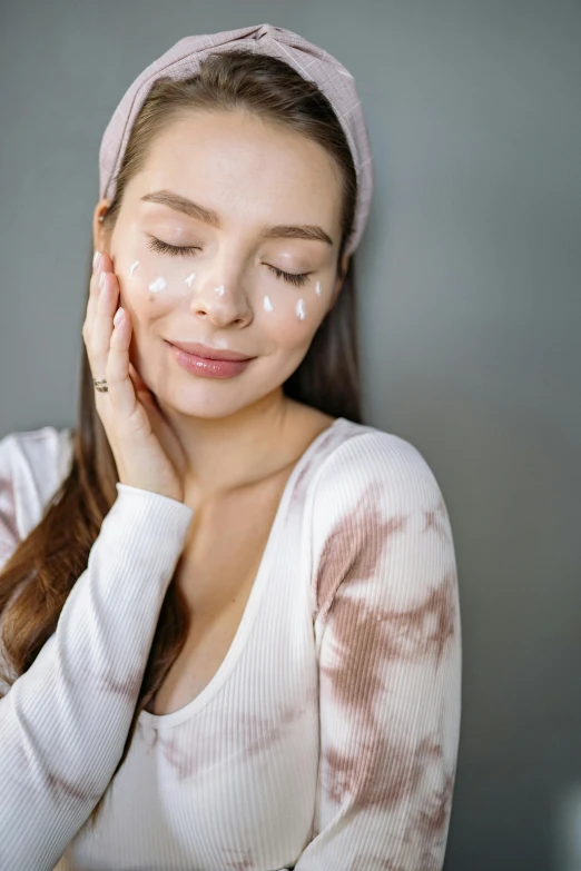 a young woman holding her hand under her face