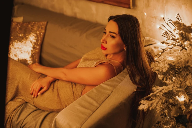 a beautiful woman laying on top of a couch