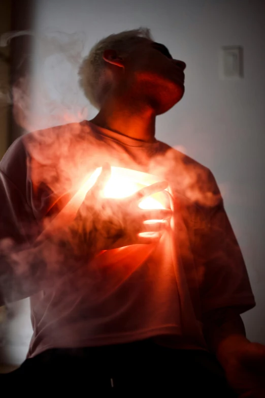 a man standing in the dark holding a glowing object